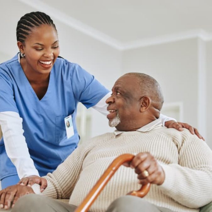 Caregiver-assisting-a-patient-get-up-from-seated-position